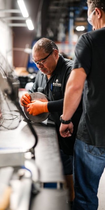Custom Rubber Solutions Mustang Seal employee working on machine.